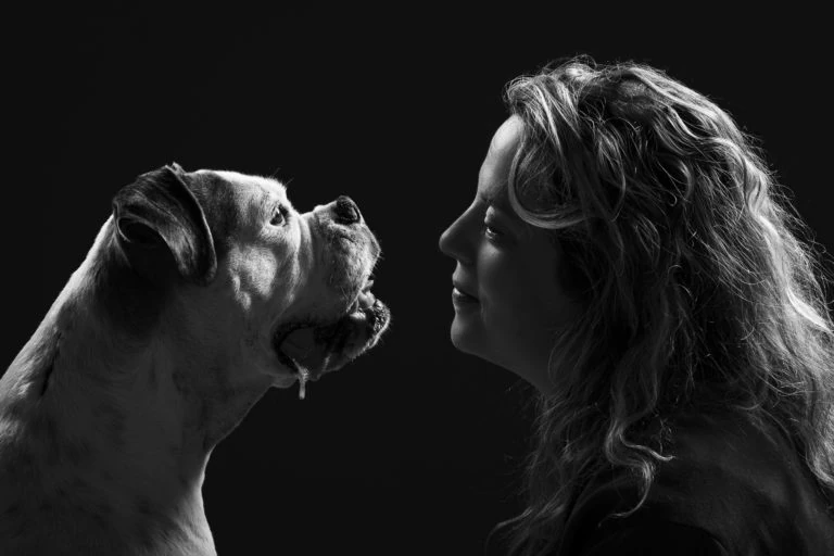 Mujer y perro mirándose en un retrato en blanco y negro