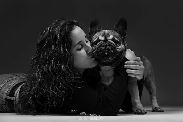 Mujer besando a su perro en un retrato en blanco y negro