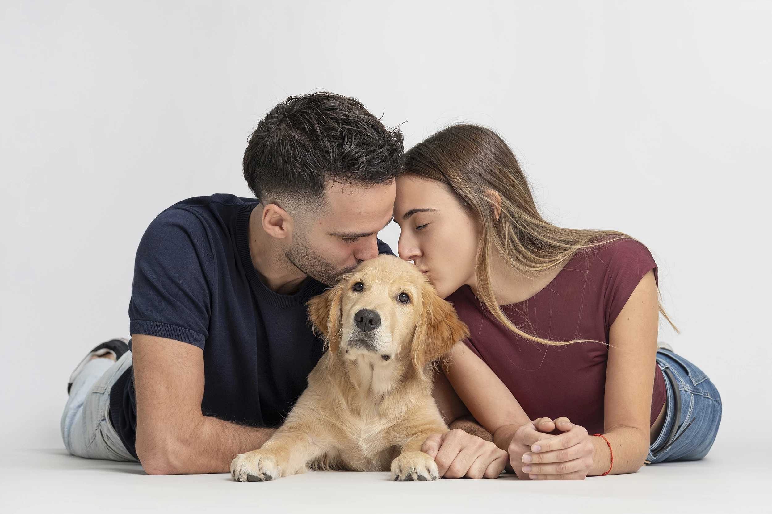 Pareja acariciando a su perro durante una sesión en estudio