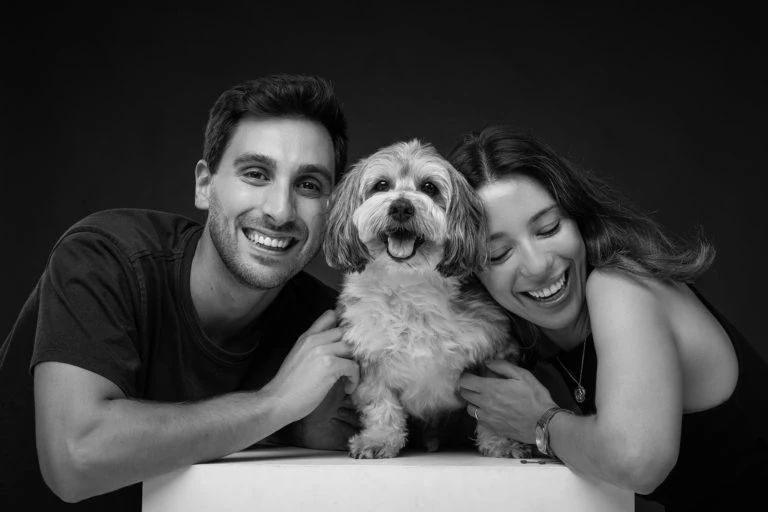 Pareja abrazando a su perro en un retrato en blanco y negro
